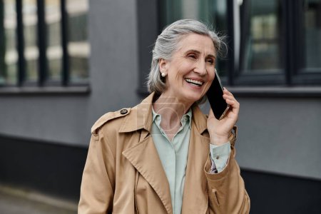 Une élégante femme âgée bavardant sur son téléphone portable.