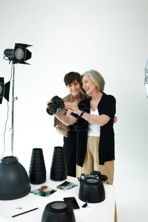 Ein lesbisches Paar mittleren Alters in einem Fotostudio; man fängt Momente mit der Kamera ein