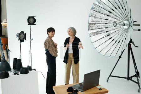 Un fotógrafo charlando con una modelo en un estudio fotográfico, pareja lesbiana