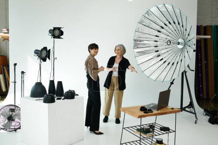 Ein lesbisches Paar mittleren Alters in einem Fotostudio; die eine ist Fotografin, die andere Model.
