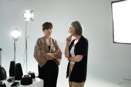 Ein lesbisches Paar mittleren Alters diskutiert in einem Fotostudio über Fotografie