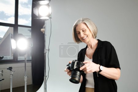 Middle-aged woman holds a camera, capturing the vibrant light.