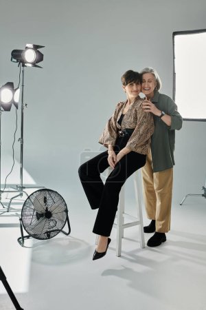 A middle-aged women styled for a photoshoot, a heartfelt hug of lesbian couple
