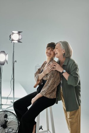 a heartfelt hug of lesbian couple captured by a camera in a photo studio setting.