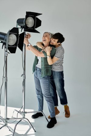 Photo for A middle-aged lesbian couple standing next to each other in a professional modern studio setting. - Royalty Free Image