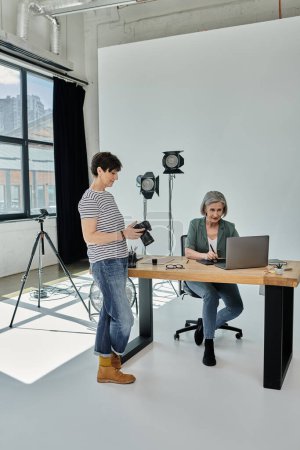 colleagues collaborating in front of a laptop in a professional photo studio.