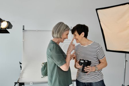 A middle aged lesbian couple standing united in a modern photo studio, exuding confidence and teamwork.