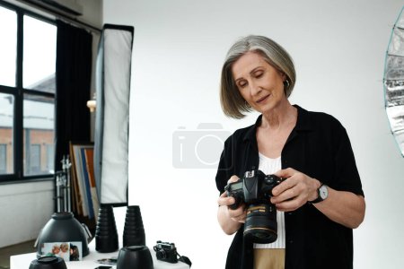 A middle-aged woman holds a camera. A creative moment in a photo studio.