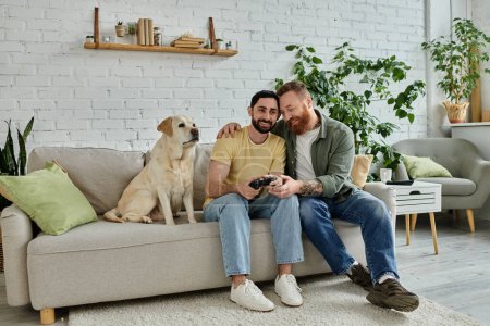 Zwei Männer, ein schwules Paar, sitzen auf einer Couch und spielen Videospiel mit ihrem Labrador-Hund in einer gemütlichen Wohnzimmeratmosphäre.