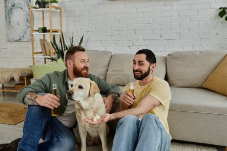 Two bearded men relax on a couch with their labrador, watching a sports match in their living room.