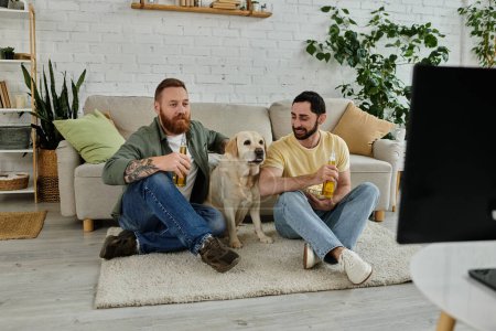 Two men with a dog watching sports on a couch in a cozy living room together.