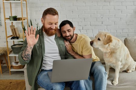 Bearded gay couple working remotely on laptop, accompanied by labrador dog, in cozy living room.