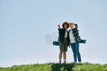 A young lesbian couple hikes through the wilderness, enjoying a sunny day together.