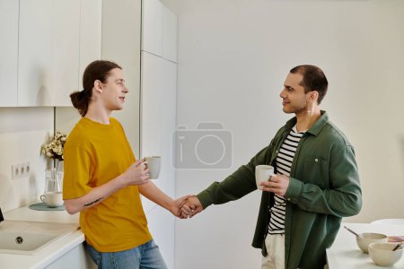 A young gay couple enjoys a morning coffee together in their modern apartment.