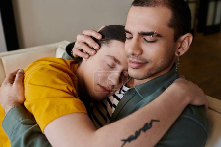 Una joven pareja gay se acurruca en un sofá de su apartamento, mostrando intimidad y comodidad.