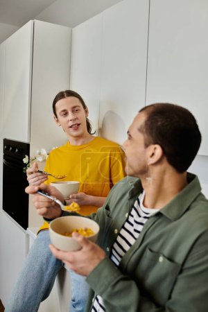 A young gay couple enjoys a casual morning meal together in their modern apartment.