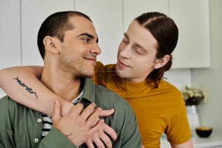 Un jeune couple gay se tient tout près dans un appartement moderne, les yeux fermés dans un moment tendre.