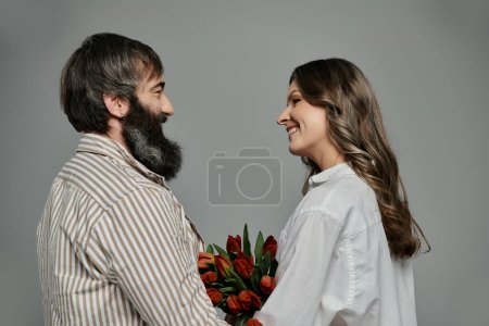 Photo for A man and woman in elegant clothing gaze lovingly at each other, capturing a tender moment. - Royalty Free Image