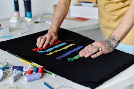 Un jeune homme arrange méticuleusement des fermetures éclair colorées sur un vêtement noir dans son atelier de restauration de vêtements, embrassant la mode durable.