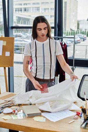 A young man meticulously examines a piece of fabric in his clothing restoration atelier. Focused on sustainability, he breathes new life into discarded clothing, creating unique pieces with a personal touch.