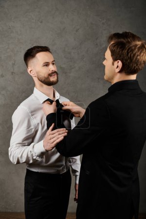 Two men in suits, one adjusting the others bow tie, showcasing love and intimacy before an event.