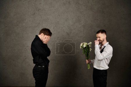 Mann im weißen Hemd überrascht Partnerin mit Strauß weißer Blumen.