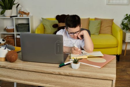 Un joven con síndrome de Down se sienta a una mesa estudiando.
