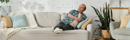A man with inclusivity relaxes on a light-colored sofa in a home setting.
