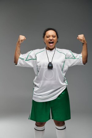 Foto de Woman in white jersey with green accents exudes sports spirit in studio. - Imagen libre de derechos