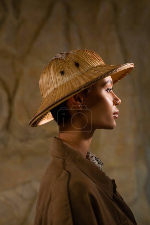 Photo for Side view of archaeologist in safari hat and brown jacket in desert - Royalty Free Image