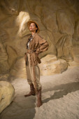 full length of archaeologist in safari hat and beige clothes standing with hand on hip in cave Sweatshirt #617057668