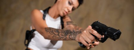 selective focus of gun in hands of blurred archaeologist, banner