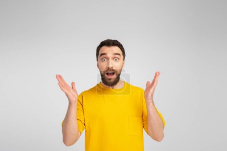 amazed man showing wow gesture while looking at camera isolated on grey