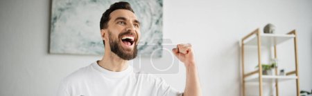 Photo for Overjoyed sports fan screaming and showing win gesture while watching game at home, banner - Royalty Free Image
