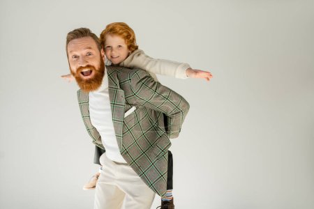 Photo for Excited bearded father playing with son isolated on grey - Royalty Free Image