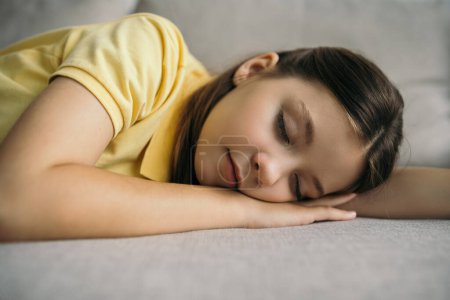 Photo for Tired preteen girl sleeping on sofa at home - Royalty Free Image