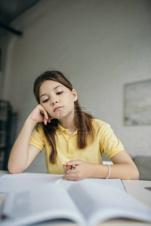 Téléchargez les photos : Fille coûteuse et fatiguée tenant stylos tout en étant assis avec la main près du visage à la maison - en image libre de droit