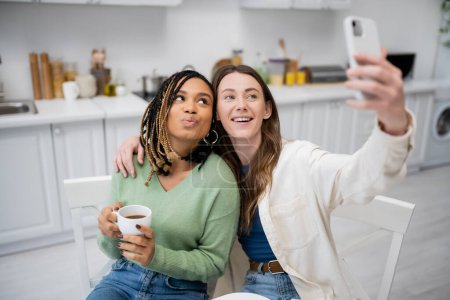 alegre lesbiana mujer tomando selfie en smartphone con africano americano novia 