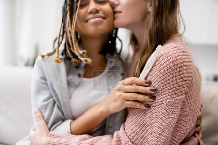 Téléchargez les photos : Jeune afro-américaine et lesbienne femme tenant test de grossesse et câlins avec petite amie - en image libre de droit