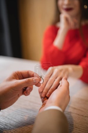 Foto de Vista recortada del hombre sosteniendo anillo de compromiso y la mano de la novia en el día de San Valentín - Imagen libre de derechos