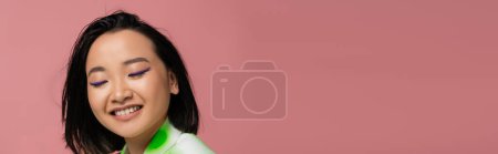 Photo for Portrait of happy asian woman with makeup and brunette hair isolated on pink, banner - Royalty Free Image