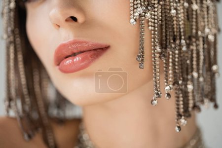 Cropped view of young woman with makeup and jewelry headwear isolated on grey 