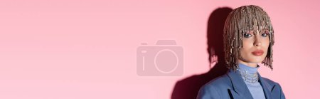 Pretty woman in luxury headwear looking at camera on pink background, banner 