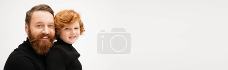Photo for Redhead boy with cheerful bearded grandfather smiling at camera isolated on grey, banner - Royalty Free Image
