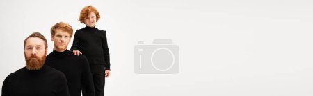 Photo for Redhead boy touching shoulder of father and smiling at camera near bearded granddad isolated on grey, banner - Royalty Free Image
