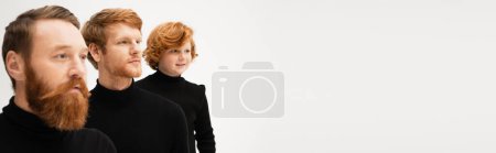 Photo for Bearded red haired men with smiling boy wearing black turtlenecks and looking away isolated on grey, banner - Royalty Free Image