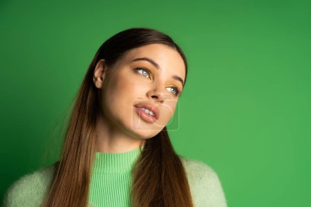 Photo for Brunette teenage girl looking away on green background - Royalty Free Image