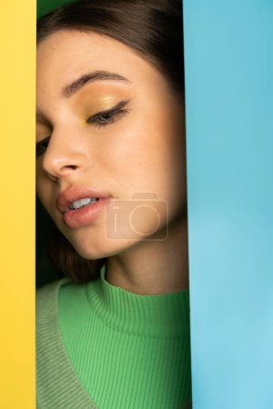 Teenager with visage posing between colorful background 