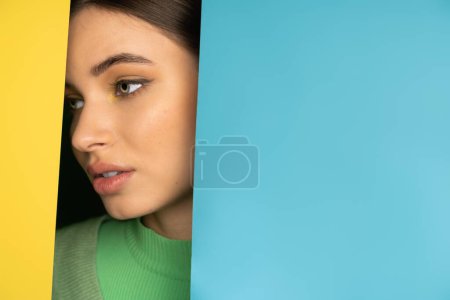 Portrait of brunette teenager looking away on colorful background with copy space