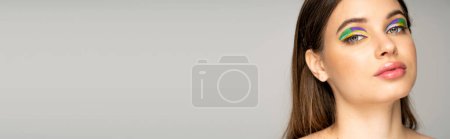 Téléchargez les photos : Portrait of teenage girl with colorful visage looking at camera isolated on grey with copy space, banner - en image libre de droit